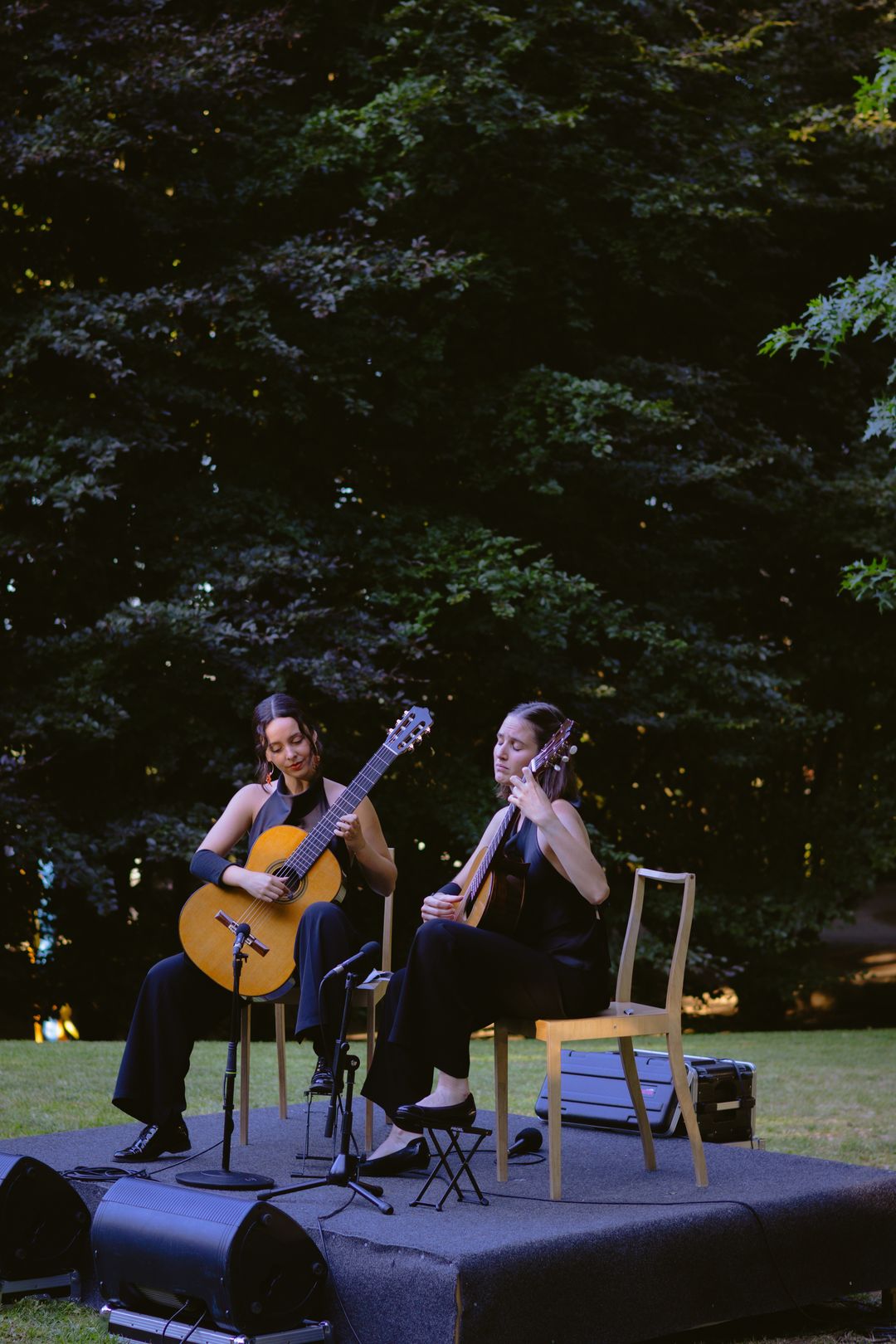 The Daniyah Guitar Duo performing on an open-air stage surrounded by trees